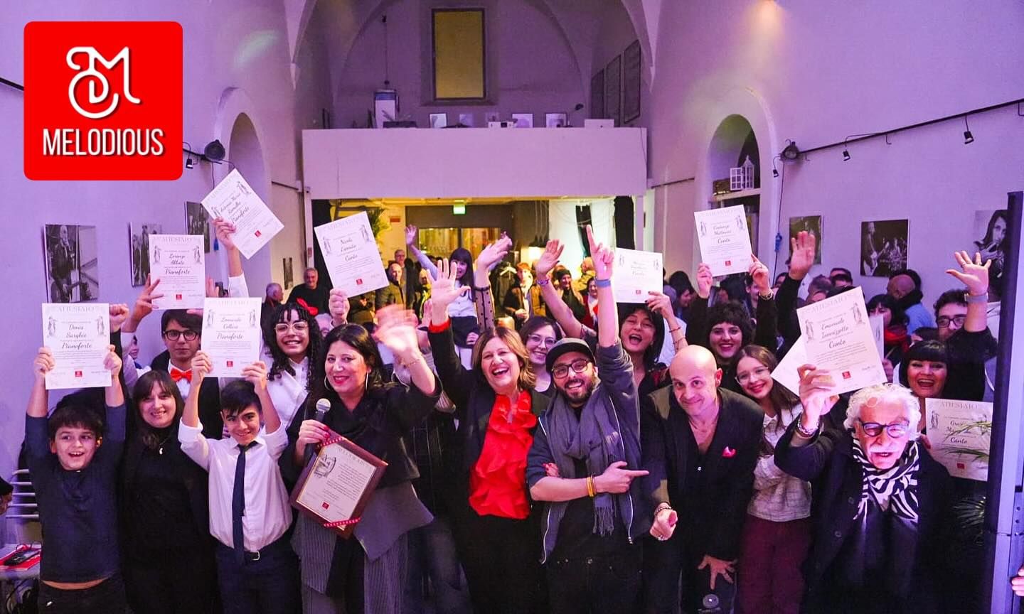 Large group photo of music school students and staff with certificates at event